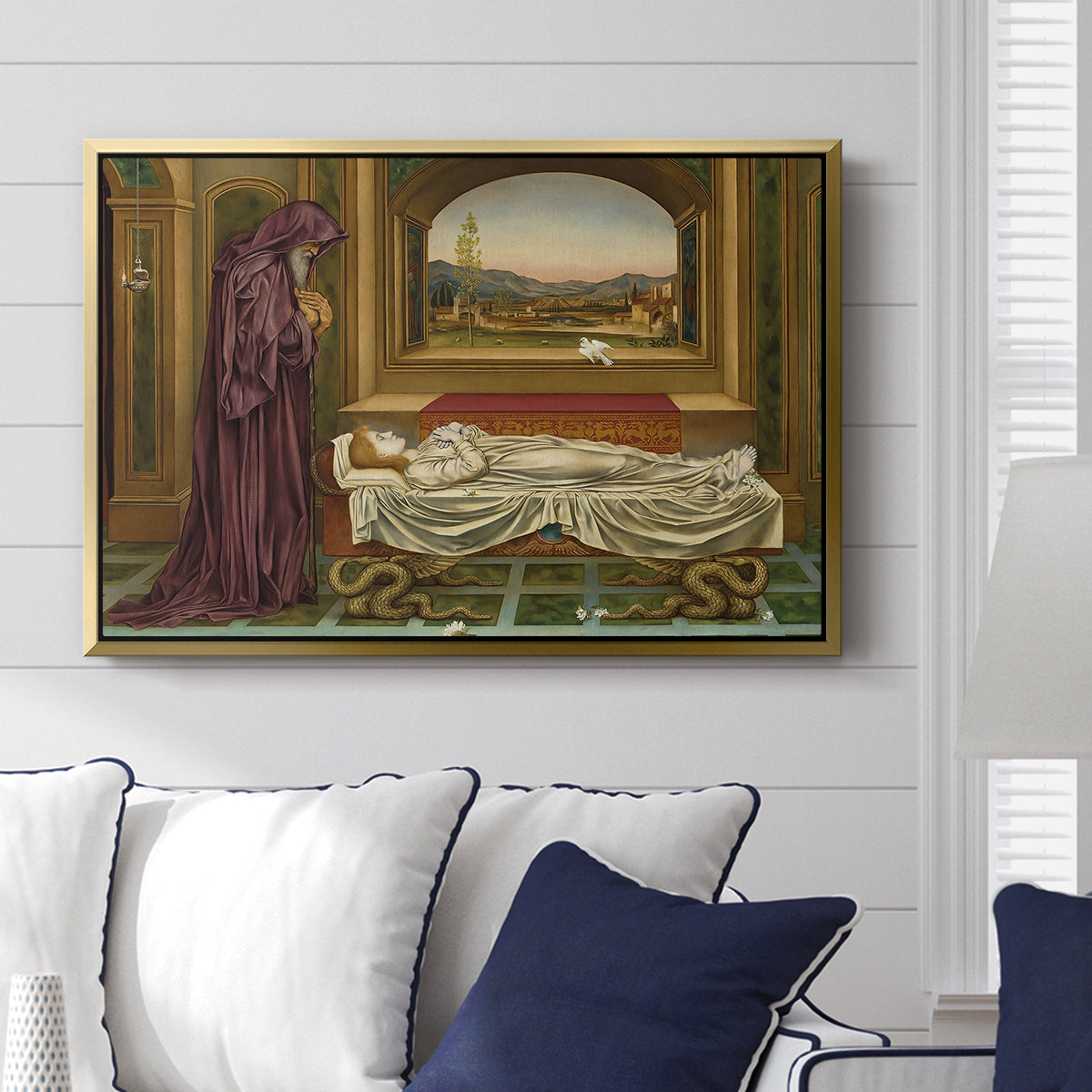 The Wandering Jew: Whom the Gods Love Die Young, 1888 by Evelyn De Morgan displayed above a sofa in a living room in a gold floater frame, featuring a symbolic portrait of wandering figure in quiet architectural setting.