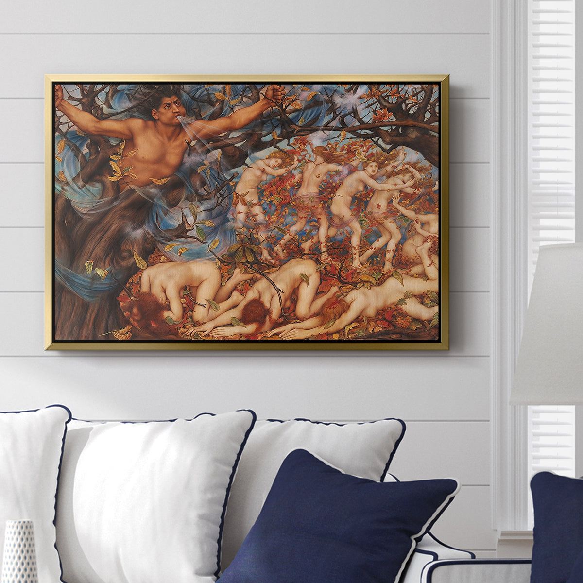 Boreas and the Fallen Leaves, c. 1910-1914 by Evelyn De Morgan displayed above a sofa in a living room in a gold floater frame, featuring a mythological scene of wind god Boreas moving through autumn leaves.