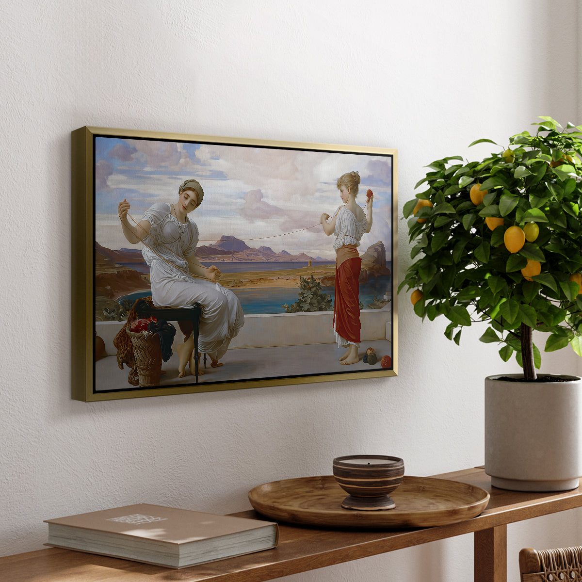 Winding the Skein, c. 1878 by Frederic Leighton, presented in a gold floater framed canvas featuring a woman holding thread while another figure helps wind yarn in classical setting, displayed above a hallway console table.