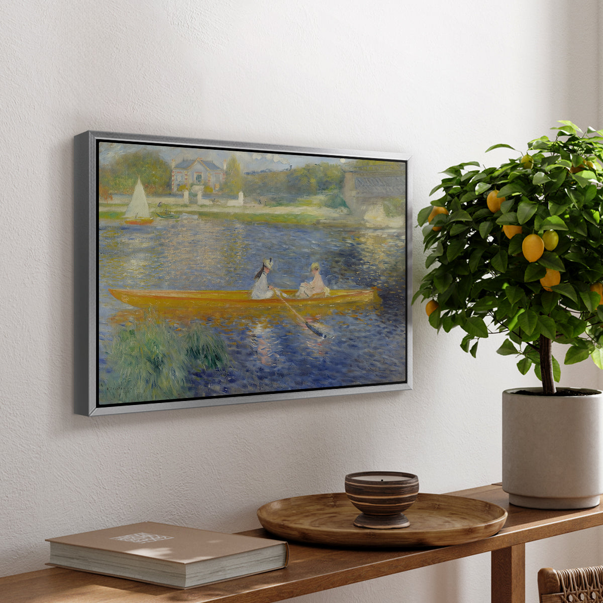 The Skiff (La Yole), 1875 by Pierre-Auguste Renoir, presented in a silver floater framed canvas featuring two figures seated in a small boat drifting across calm water, displayed above a hallway console table.