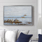 Greylag Geese (Grågäss), 1922 by Bruno Liljefors displayed above a sofa in a living room in a silver floater frame, featuring birds standing and resting along shoreline with soft grass and water.