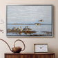 Silver floater framed canvas featuring a realistic wildlife scene of geese in calm outdoor environment, displayed above a cabinet in a soft-toned living room.