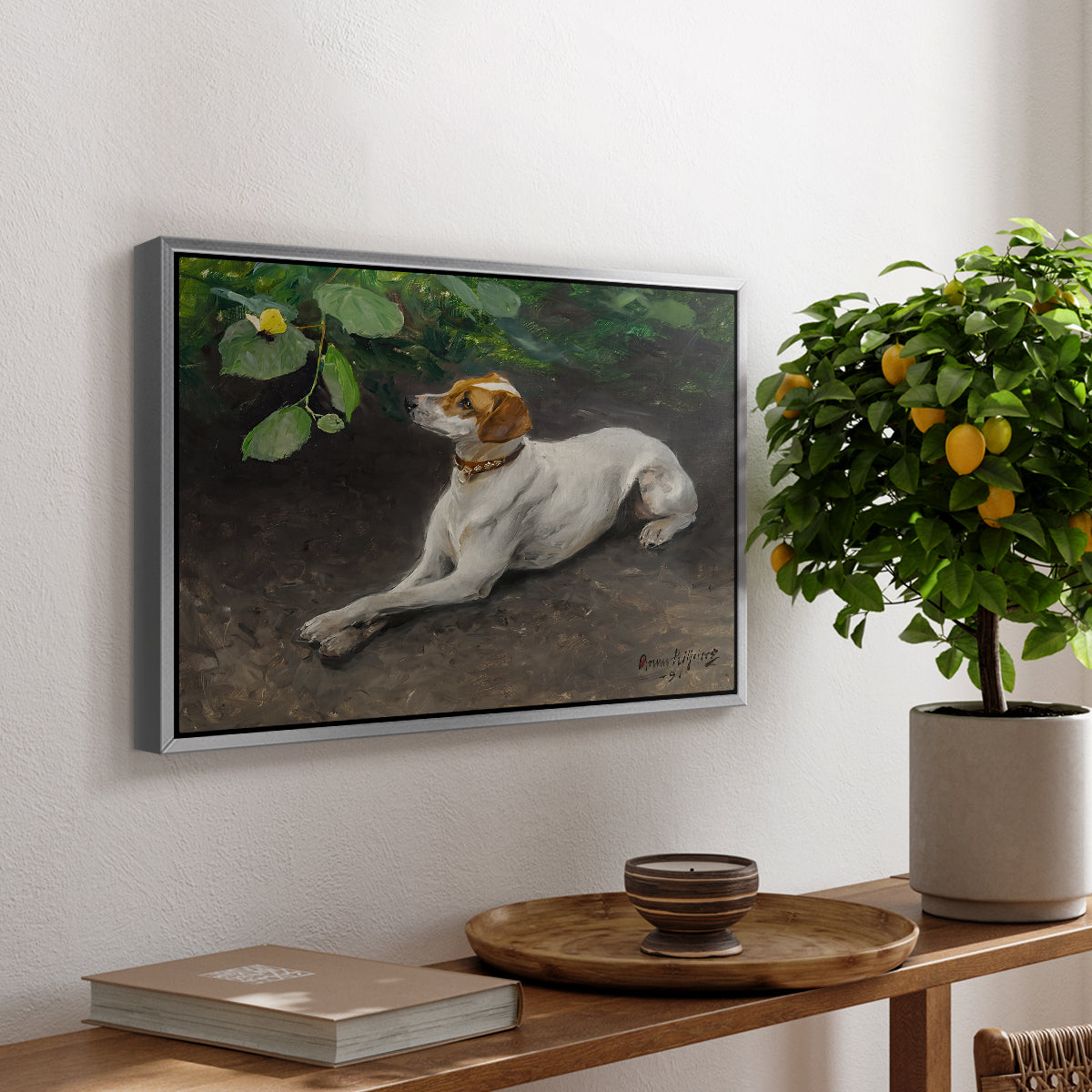 Portrait of a Dog, 1891 by Bruno Liljefors, presented in a silver floater framed canvas featuring a dog lying on ground with head raised in natural outdoor setting, displayed above a hallway console table.