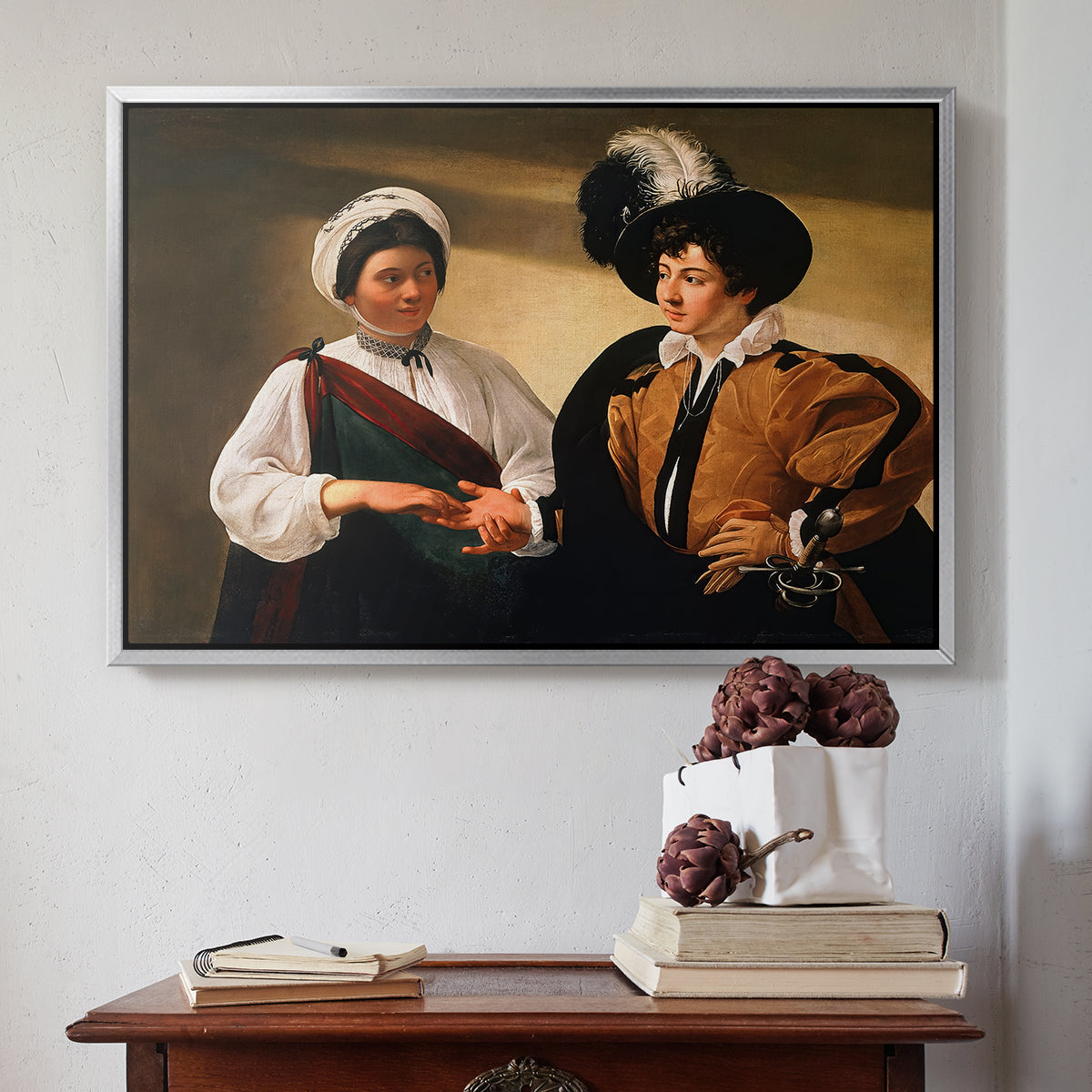 Silver floater framed canvas featuring The Fortune Teller (Louvre Version), c. 1595 by Caravaggio above an entryway table in a minimalist foyer.