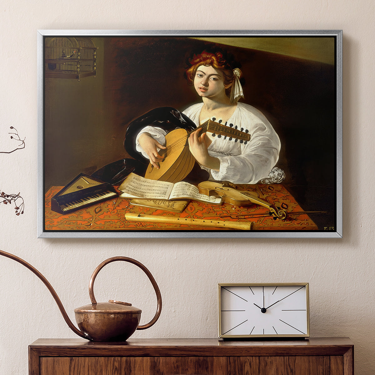 Silver floater framed canvas featuring a detailed scene of youth playing string instrument with fruit and flowers nearby, displayed above a cabinet in a soft-toned living room.