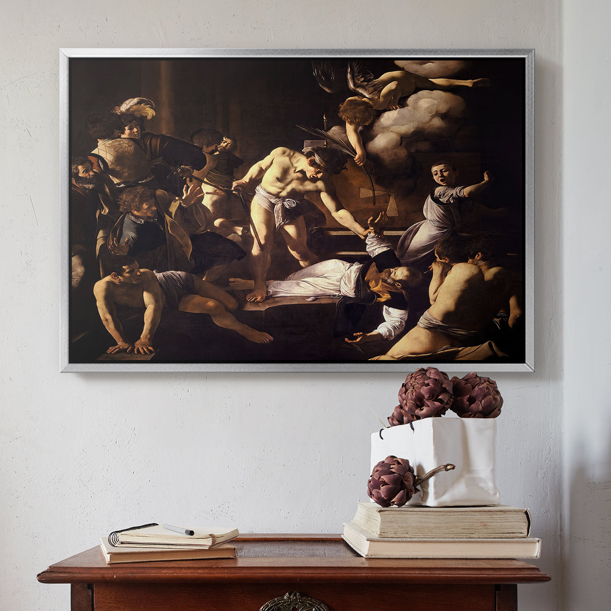 Silver floater framed canvas featuring The Martyrdom of Saint Matthew, 1599-1600 by Caravaggio above an entryway table in a minimalist foyer.