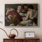 Silver floater framed canvas featuring an intimate scene of youths making music with sheet music and instruments, displayed above a cabinet in a soft-toned living room.