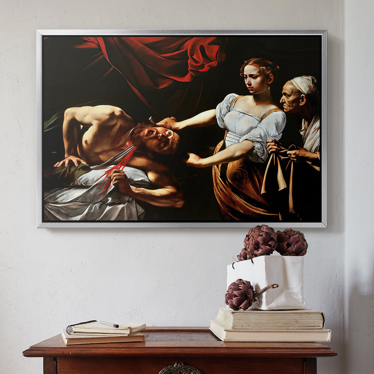 Silver floater framed canvas featuring Judith Beheading Holofernes, c. 1599 by Caravaggio above an entryway table in a minimalist foyer.