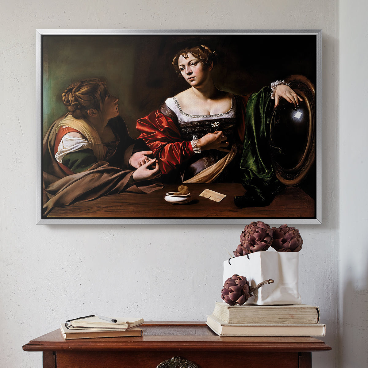 Silver floater framed canvas featuring Martha and Mary Magdalene, c. 1598 by Caravaggio above an entryway table in a minimalist foyer.