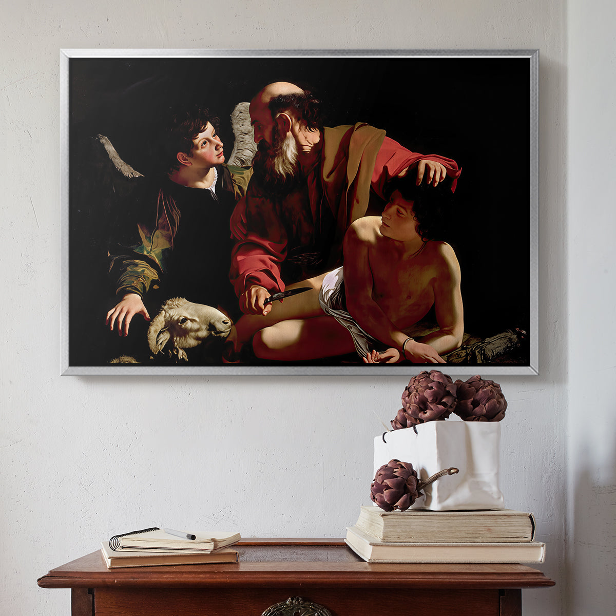 Silver floater framed canvas featuring The Sacrifice of Isaac (Uffizi Version), c. 1603 by Caravaggio above an entryway table in a minimalist foyer.