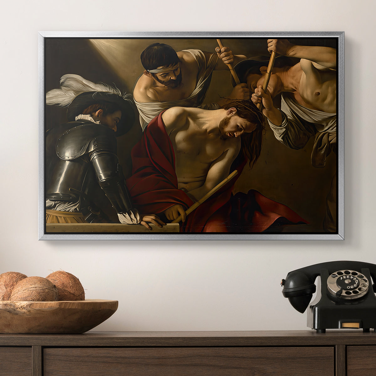 The Crowning with Thorns (Vienna Version), c. 1602-1604 by Caravaggio in a silver floater framed canvas displayed above a console table in a hallway, featuring an intense religious composition with strong shadow and physical struggle.