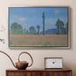 Silver floater framed canvas featuring a vibrant meadow scene with flowers and vertical tree forms, displayed above a cabinet in a soft-toned living room.