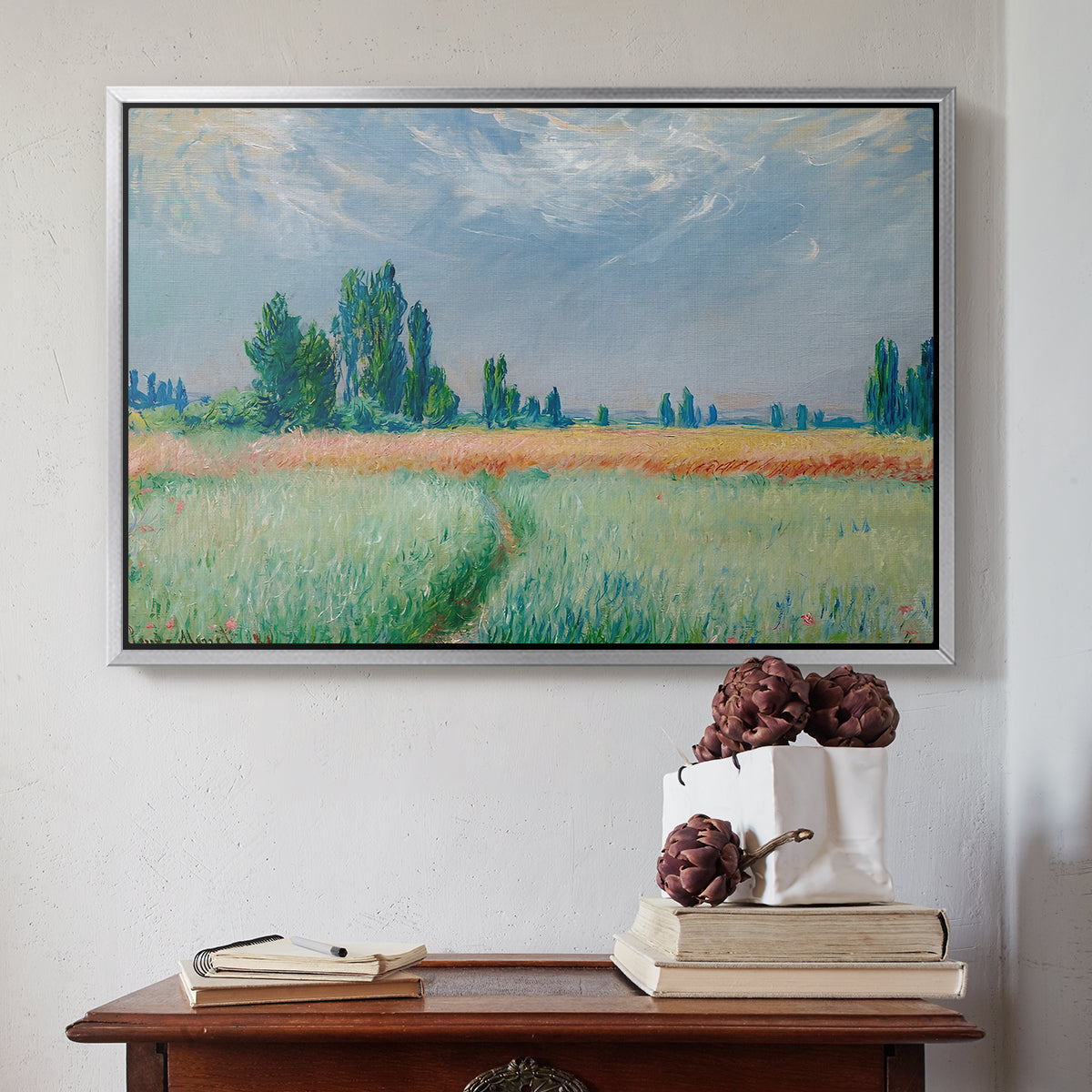 Silver floater framed canvas featuring The Wheat Field (Champ de Blé), 1881 by Claude Monet above an entryway table in a minimalist foyer.