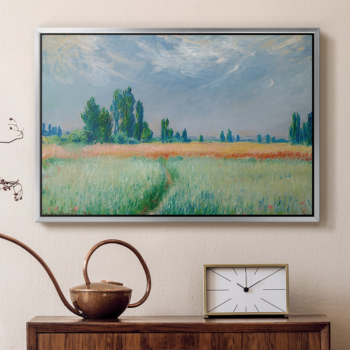 Silver floater framed canvas featuring an agricultural landscape with tall wheat and distant horizon, displayed above a cabinet in a soft-toned living room.