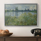 Banks of the Seine, Vétheuil, 1880 by Claude Monet in a silver floater framed canvas displayed above a console table in a hallway, featuring a natural landscape with calm water and soft foliage.