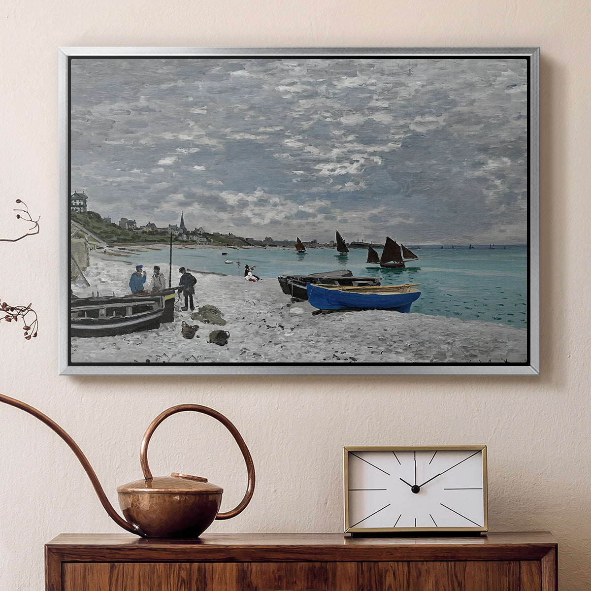 Silver floater framed canvas featuring a coastal landscape with sailboats and visitors on cliffside, displayed above a cabinet in a soft-toned living room.