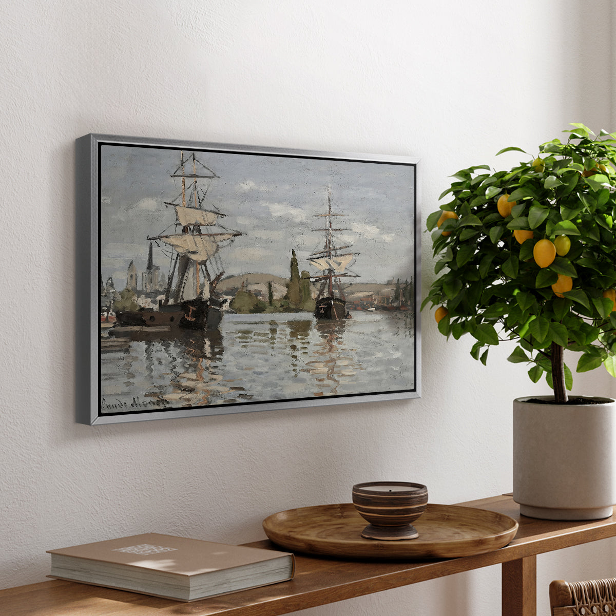 Ships Riding on the Seine at Rouen, 1872 by Claude Monet, presented in a silver floater framed canvas featuring large ships docked along the Seine with masts rising against soft sky, displayed above a hallway console table.