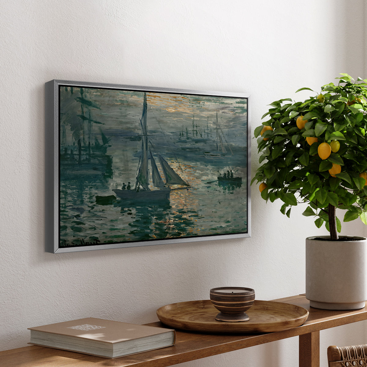 Sunrise (Marine), 1873 by Claude Monet, presented in a silver floater framed canvas featuring a hazy sunrise over harbor with boats silhouetted in soft morning light, displayed above a hallway console table.