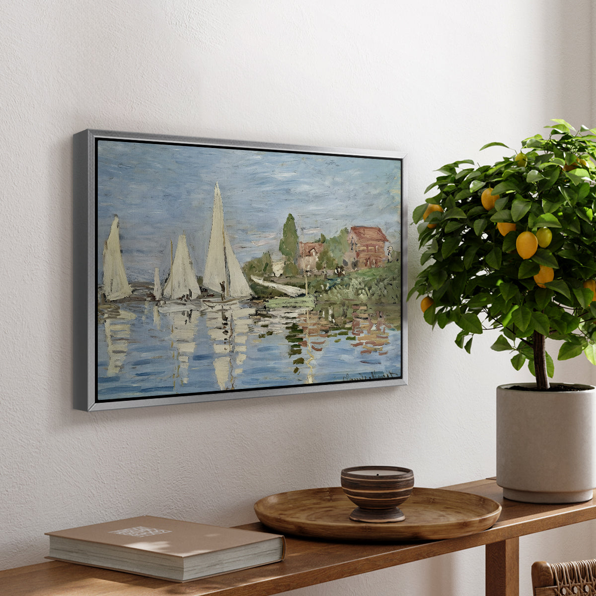 Regatta at Argenteuil, 1872 by Claude Monet, presented in a silver floater framed canvas featuring colorful sailboats racing across river under bright sky, displayed above a hallway console table.