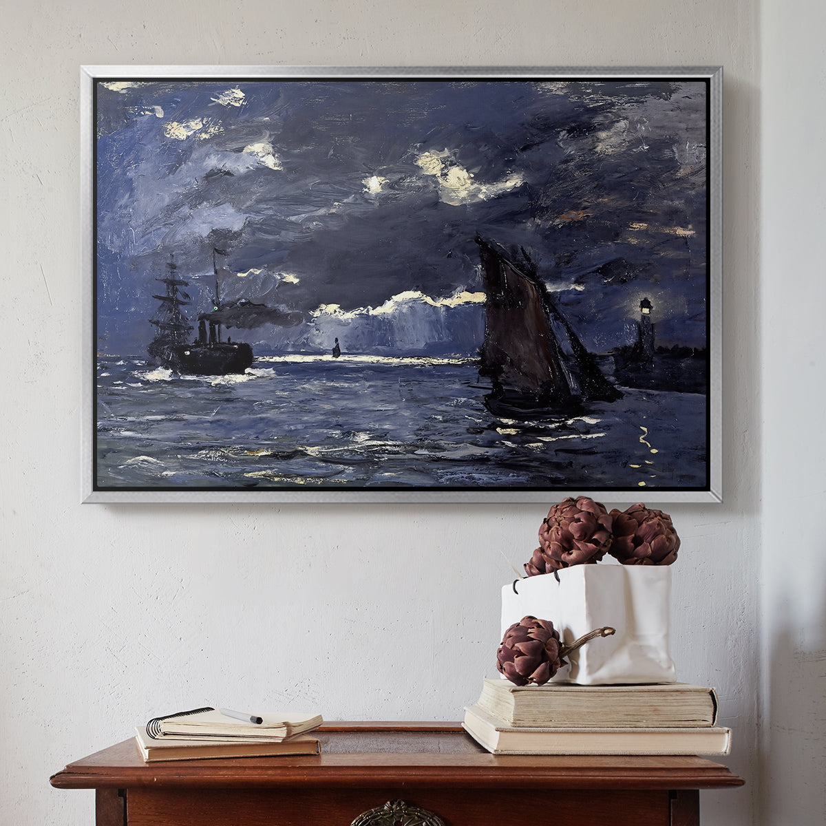 Silver floater framed canvas featuring A Seascape, Shipping by Moonlight, 1864 by Claude Monet above an entryway table in a minimalist foyer.