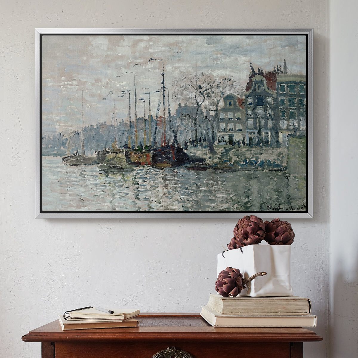 Silver floater framed canvas featuring View of the Prins Hendrikkade and Kromme Waal in Amsterdam, 1874 by Claude Monet above an entryway table in a minimalist foyer.