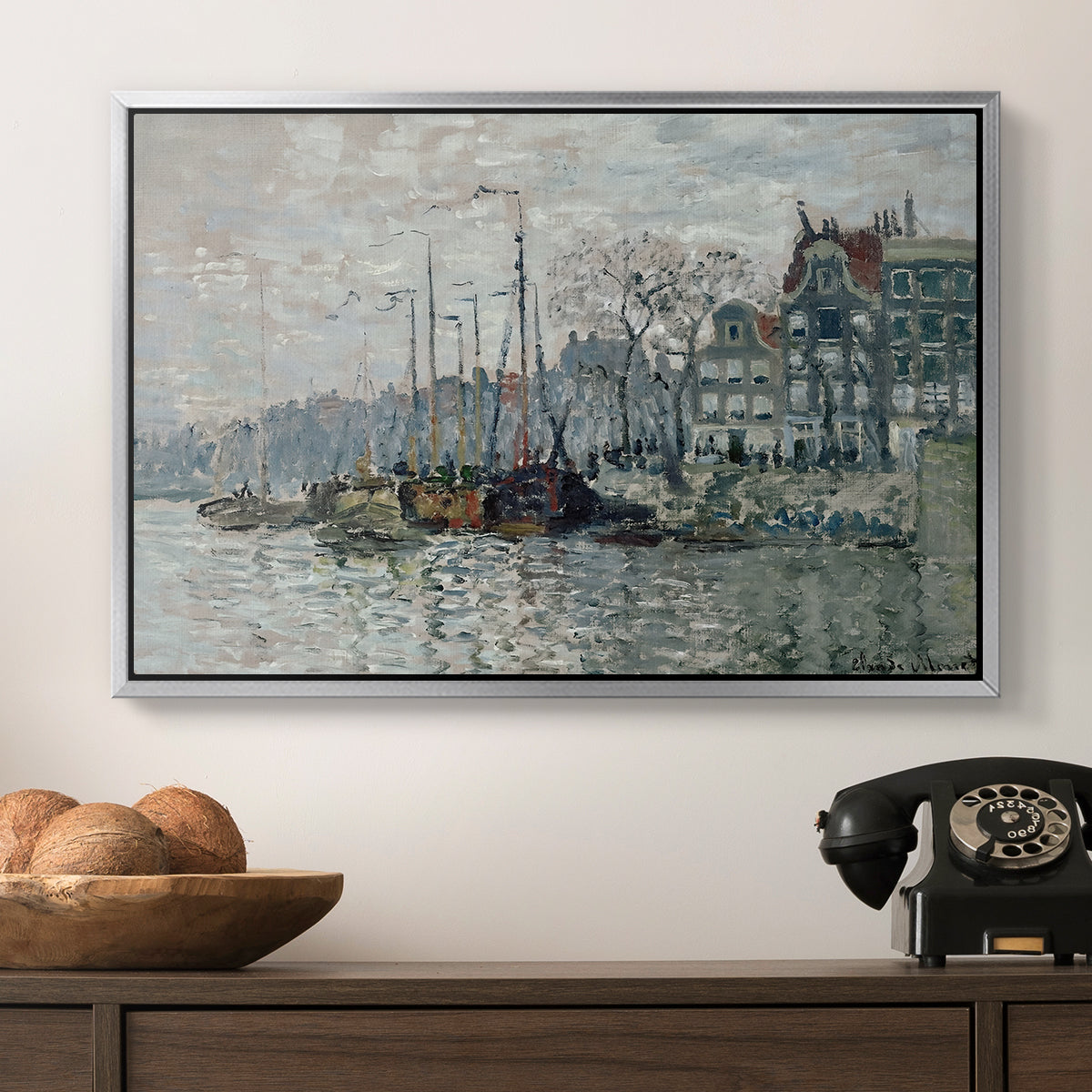 View of the Prins Hendrikkade and Kromme Waal in Amsterdam, 1874 by Claude Monet in a silver floater framed canvas displayed above a console table in a hallway, featuring a harbor view with masts, houses, and reflections in water.