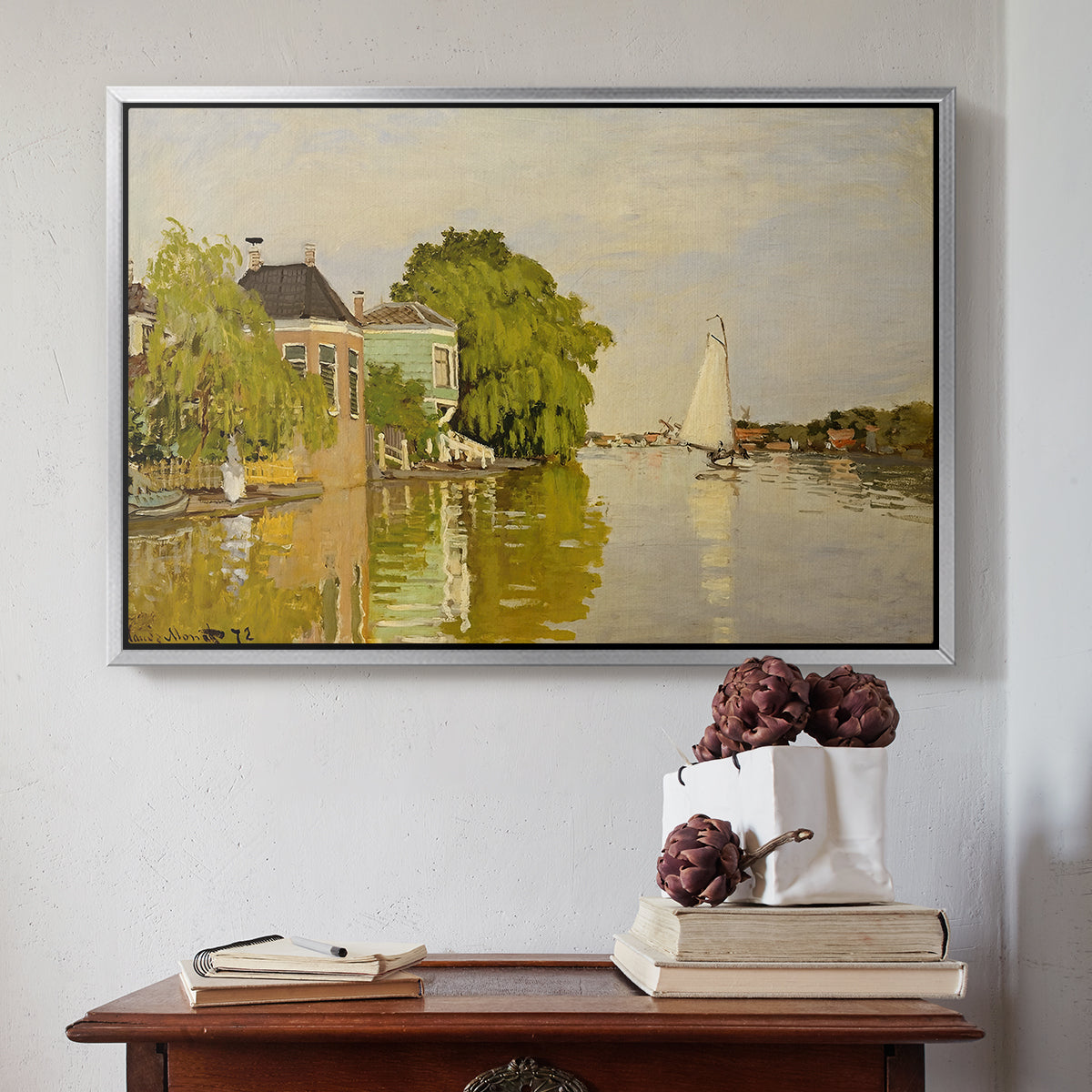 Silver floater framed canvas featuring Houses on the Achterzaan, 1871 by Claude Monet above an entryway table in a minimalist foyer.