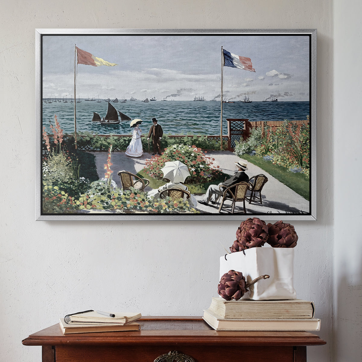 Silver floater framed canvas featuring Garden at Sainte-Adresse, 1867 by Claude Monet above an entryway table in a minimalist foyer.