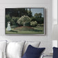 Woman in the Garden, Sainte-Adresse, 1867 by Claude Monet displayed above a sofa in a living room in a silver floater frame, featuring an impressionist figure in sunlit garden with lush vegetation.