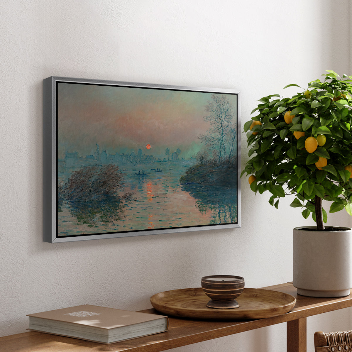 Sunset on the Seine at Lavacourt, Winter Effect, 1880 by Claude Monet, presented in a silver floater framed canvas featuring a glowing sunset over snowy river landscape with soft reflections, displayed above a hallway console table.