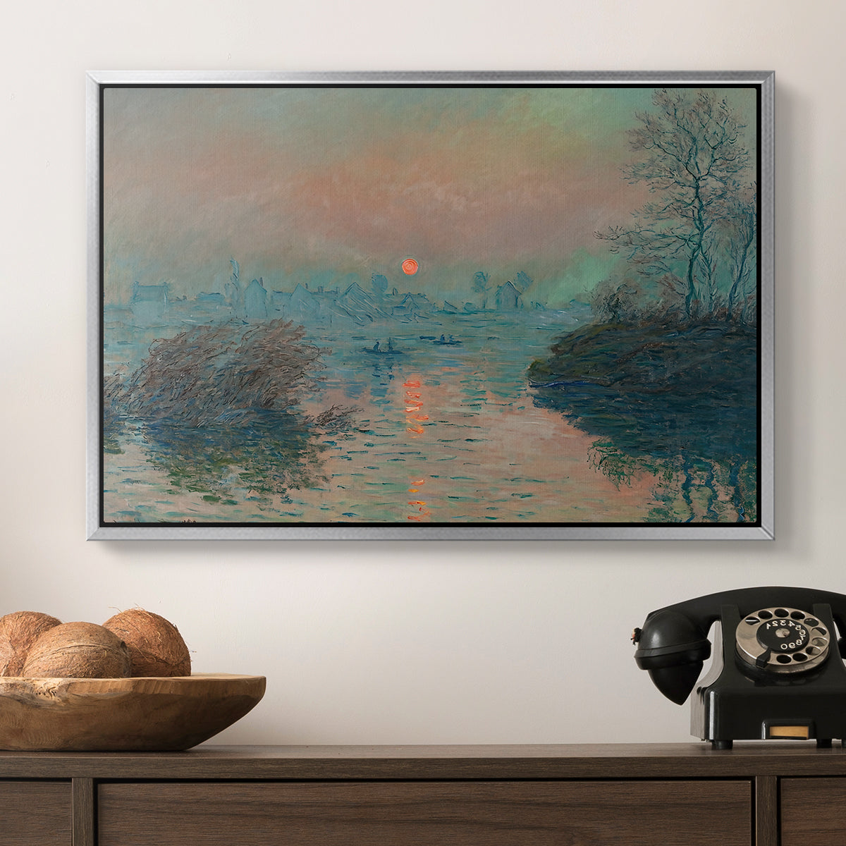 Sunset on the Seine at Lavacourt, Winter Effect, 1880 by Claude Monet in a silver floater framed canvas displayed above a console table in a hallway, featuring an atmospheric landscape combining cold tones and warm sky.