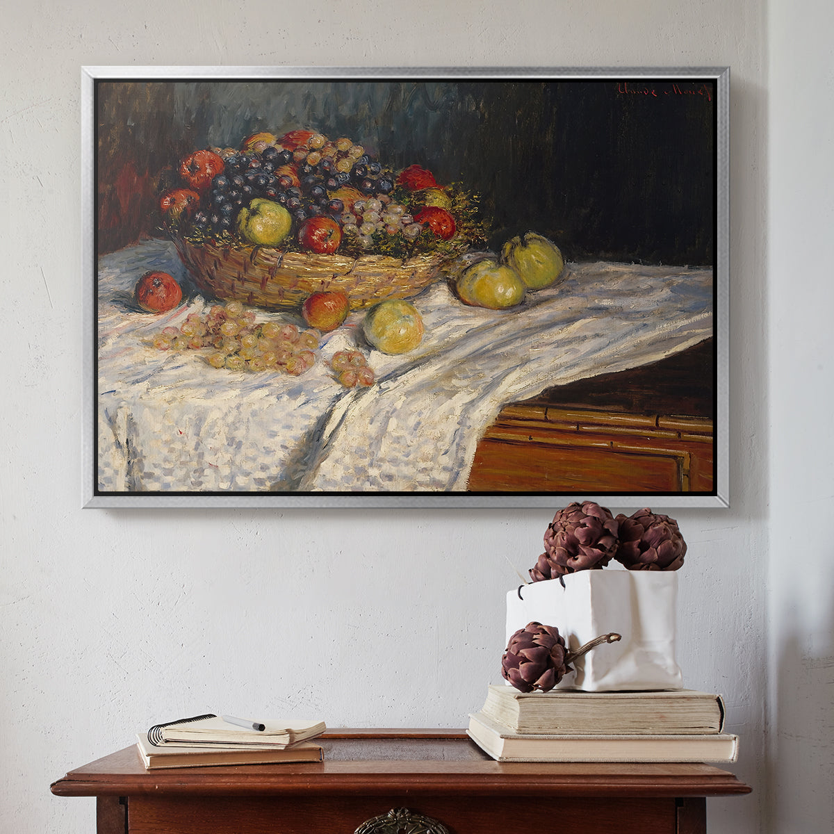 Silver floater framed canvas featuring Still Life with Apples and Grapes, 1880 by Claude Monet above an entryway table in a minimalist foyer.