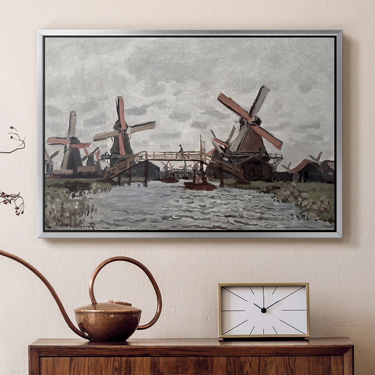 Silver floater framed canvas featuring a countryside scene with traditional windmills and reflections, displayed above a cabinet in a soft-toned living room.