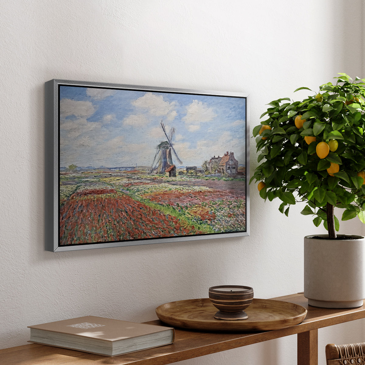 Tulip Fields with the Rijnsburg Windmill, 1886 by Claude Monet, presented in a silver floater framed canvas featuring colorful rows of tulip fields leading toward distant windmill, displayed above a hallway console table.