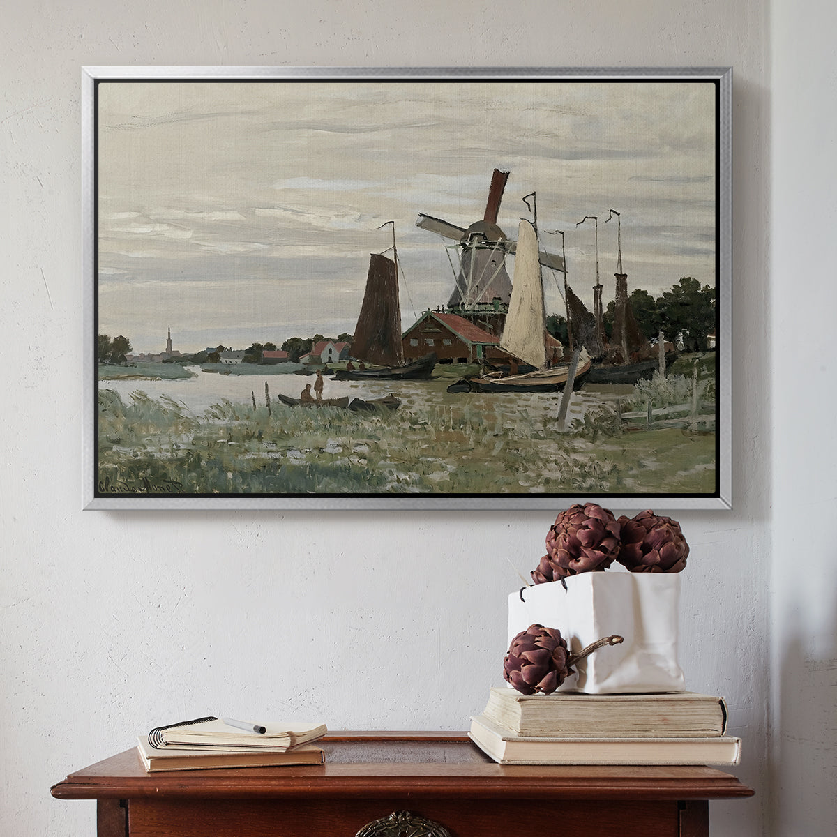 Silver floater framed canvas featuring Windmill at Zaandam, 1871 by Claude Monet above an entryway table in a minimalist foyer.
