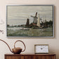 Silver floater framed canvas featuring a rustic scene with windmill and reflections in water, displayed above a cabinet in a soft-toned living room.
