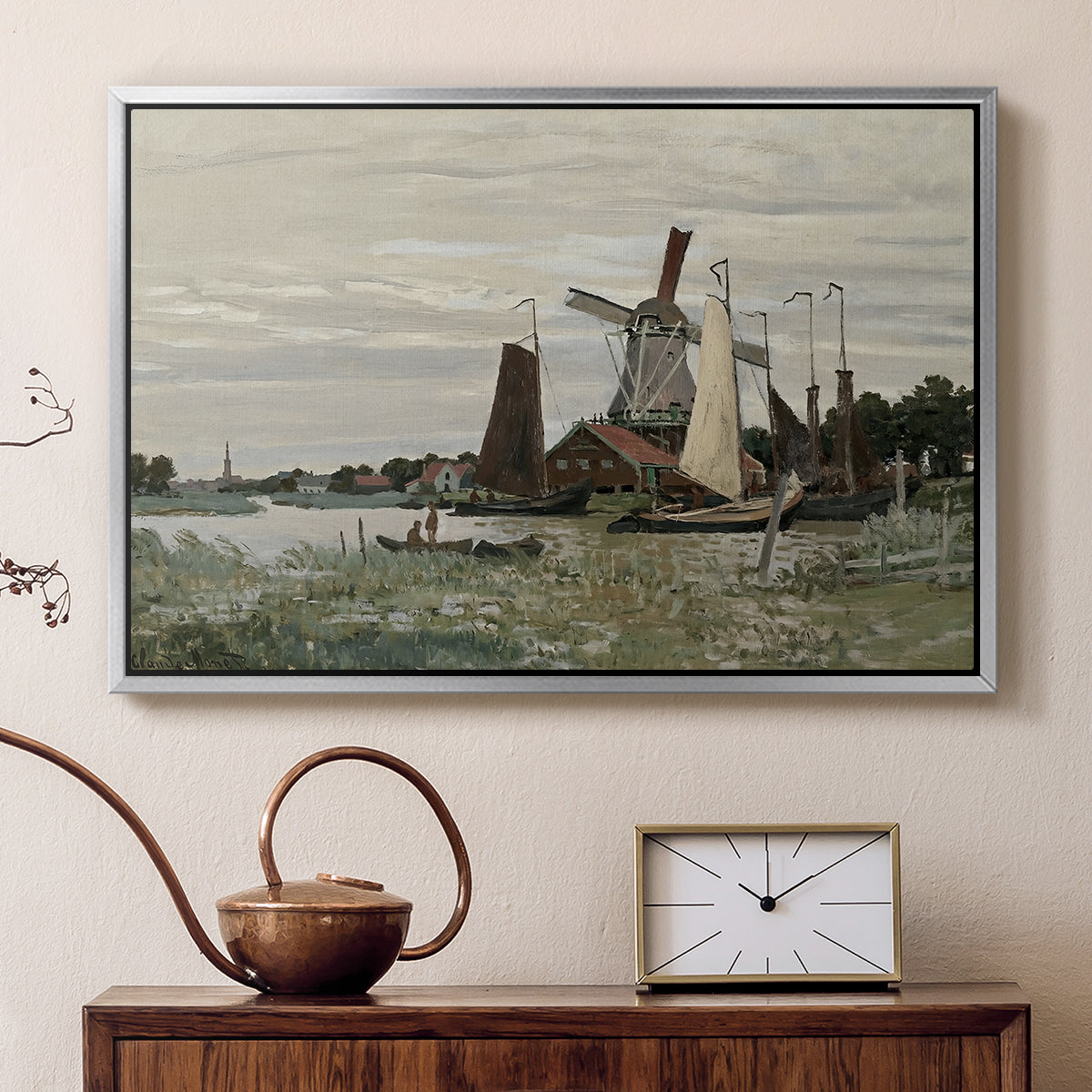 Silver floater framed canvas featuring a rustic scene with windmill and reflections in water, displayed above a cabinet in a soft-toned living room.