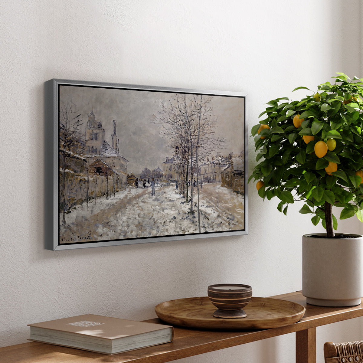 The Boulevard de Pontoise at Argenteuil, Snow Effect, 1875 by Claude Monet, presented in a silver floater framed canvas featuring a snow-covered street lined with trees and buildings under winter sky, displayed above a hallway console table.