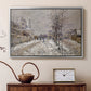 Silver floater framed canvas featuring a quiet boulevard blanketed in snow with distant figures, displayed above a cabinet in a soft-toned living room.