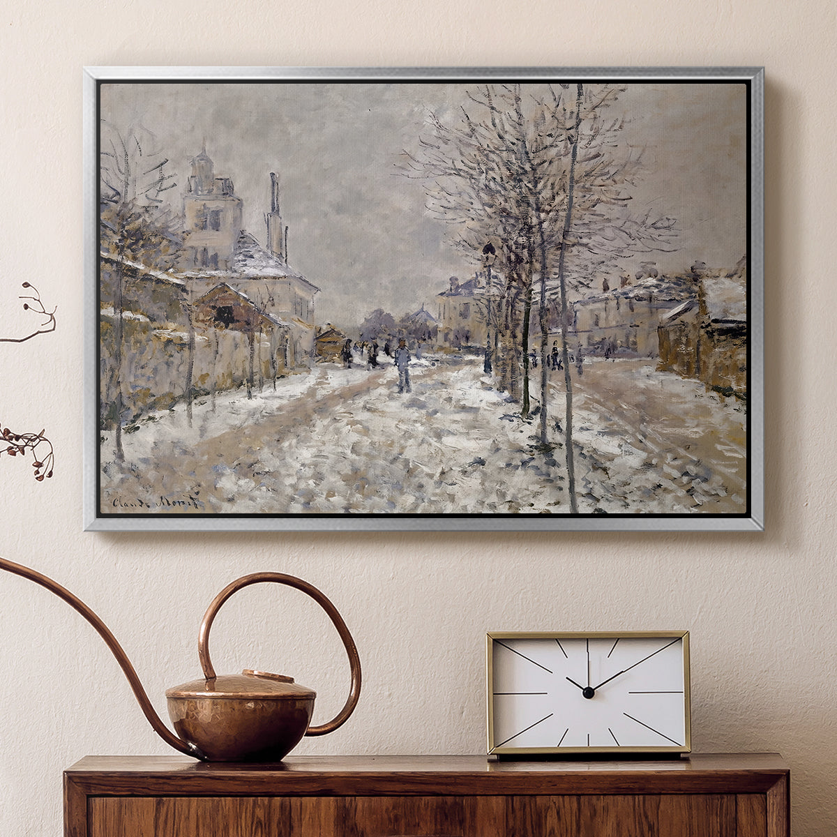 Silver floater framed canvas featuring a quiet boulevard blanketed in snow with distant figures, displayed above a cabinet in a soft-toned living room.