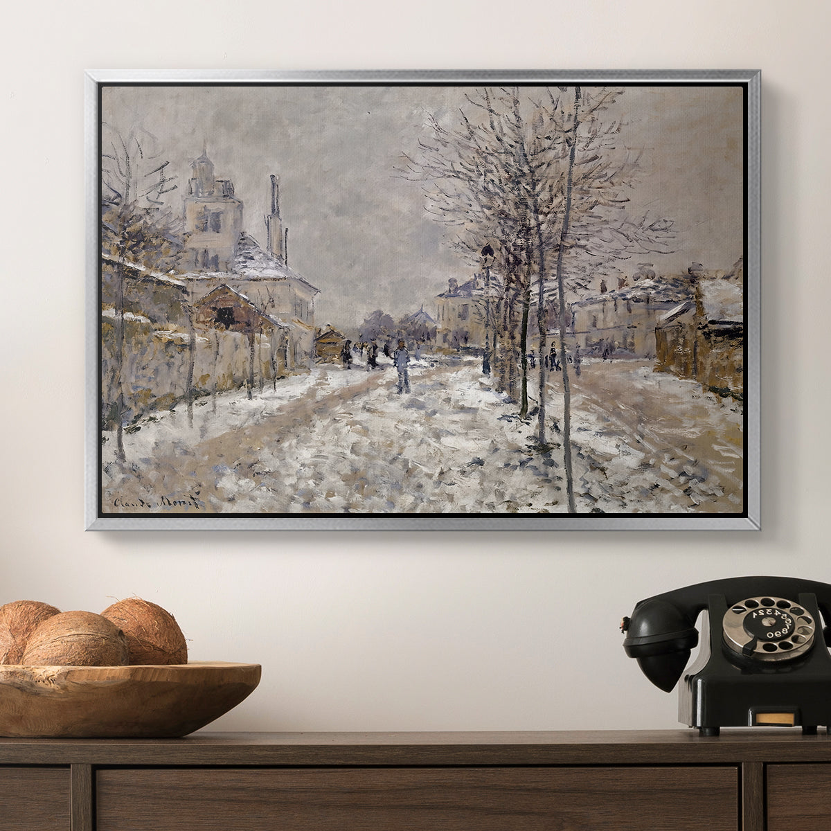 The Boulevard de Pontoise at Argenteuil, Snow Effect, 1875 by Claude Monet in a silver floater framed canvas displayed above a console table in a hallway, featuring an urban winter landscape with muted tones and soft light.