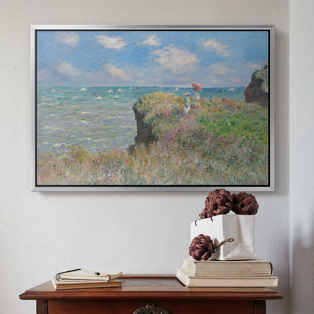 Silver floater framed canvas featuring The Cliff Walk at Pourville, 1882 by Claude Monet above an entryway table in a minimalist foyer.