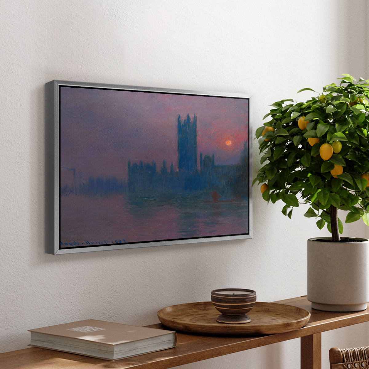 The Houses of Parliament, Sunset, 1903 by Claude Monet, presented in a silver floater framed canvas featuring a silhouette of Parliament buildings against glowing sunset across river, displayed above a hallway console table.
