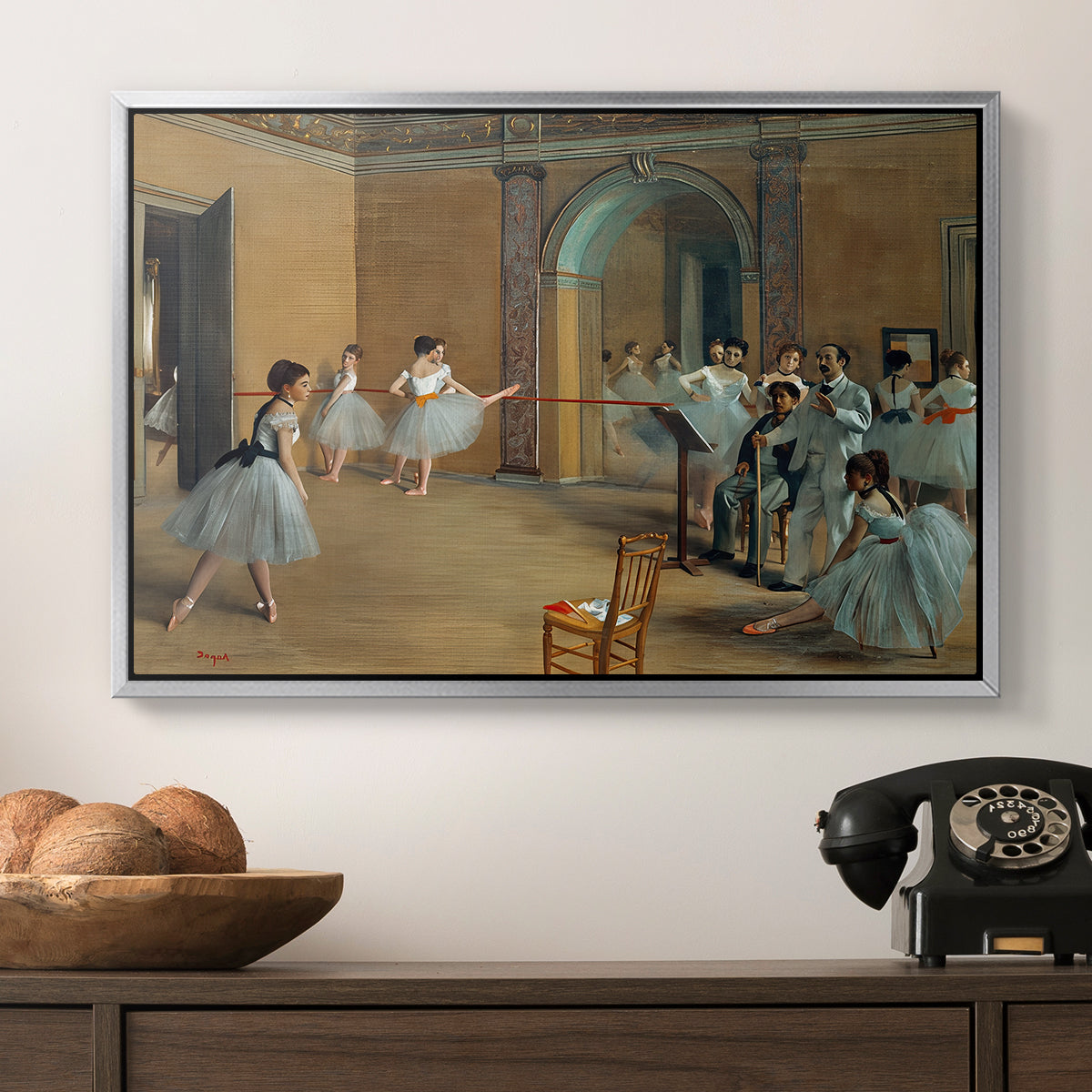 The Dance Foyer at the Opera on the Rue Le Peletier, 1872 by Edgar Degas in a silver floater framed canvas displayed above a console table in a hallway, featuring an elegant rehearsal space with dancers in soft lighting.