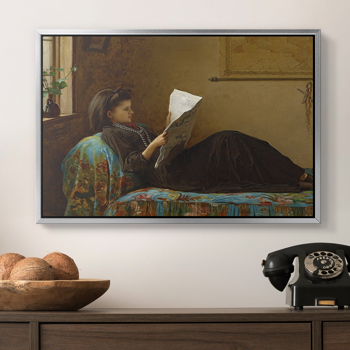 Interesting News, 1872 by Eastman Johnson in a silver floater framed canvas displayed above a console table in a hallway, featuring a casual gathering around newspaper in rustic room.
