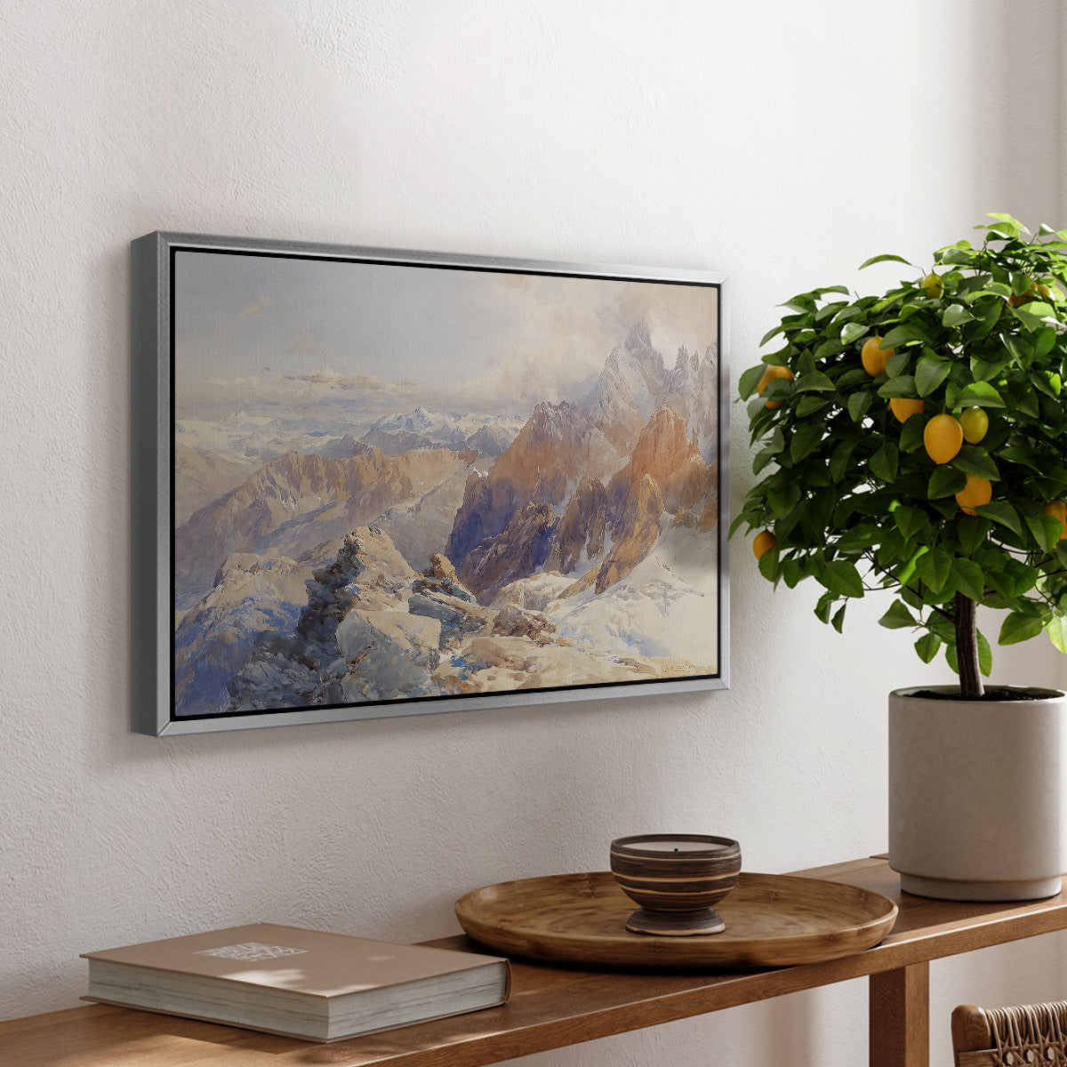 Col du Géant, 1903 by Edward Theodore Compton, presented in a silver floater framed canvas featuring a mountain pass with snow-covered peaks and expansive alpine valley, displayed above a hallway console table.