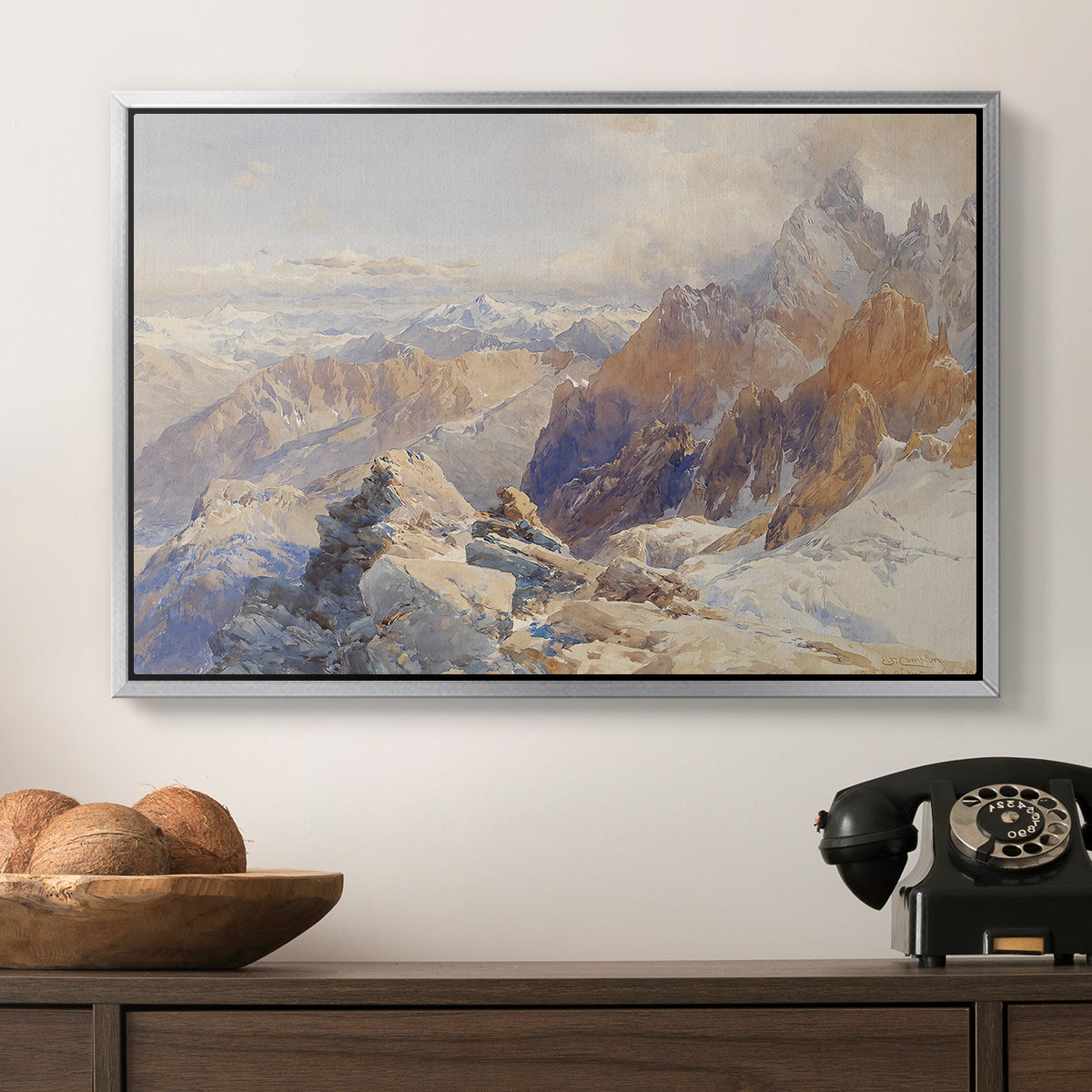 Col du Géant, 1903 by Edward Theodore Compton in a silver floater framed canvas displayed above a console table in a hallway, featuring a rugged mountain pass scene with distant peaks.