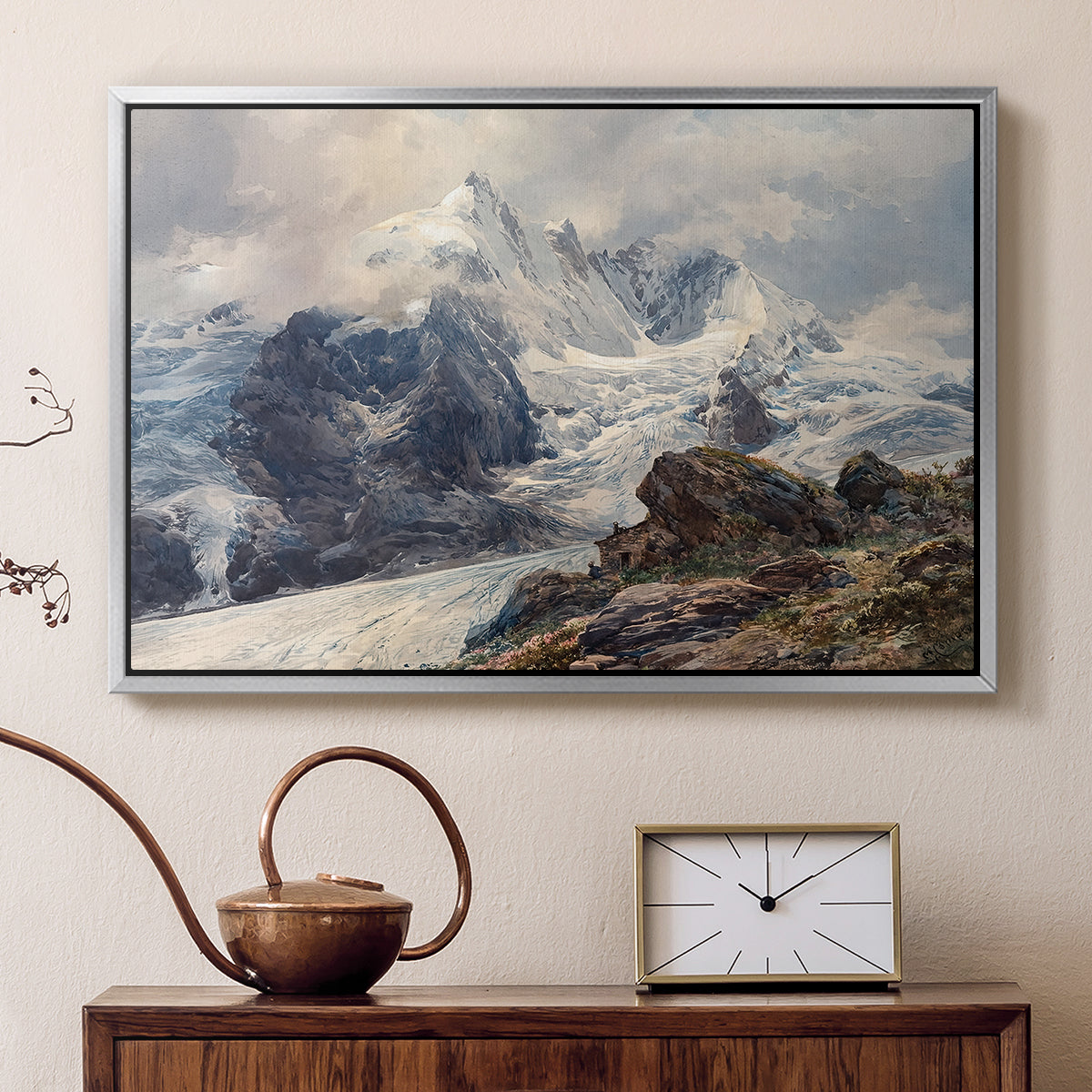 Silver floater framed canvas featuring a realistic landscape of high mountain under open sky, displayed above a cabinet in a soft-toned living room.