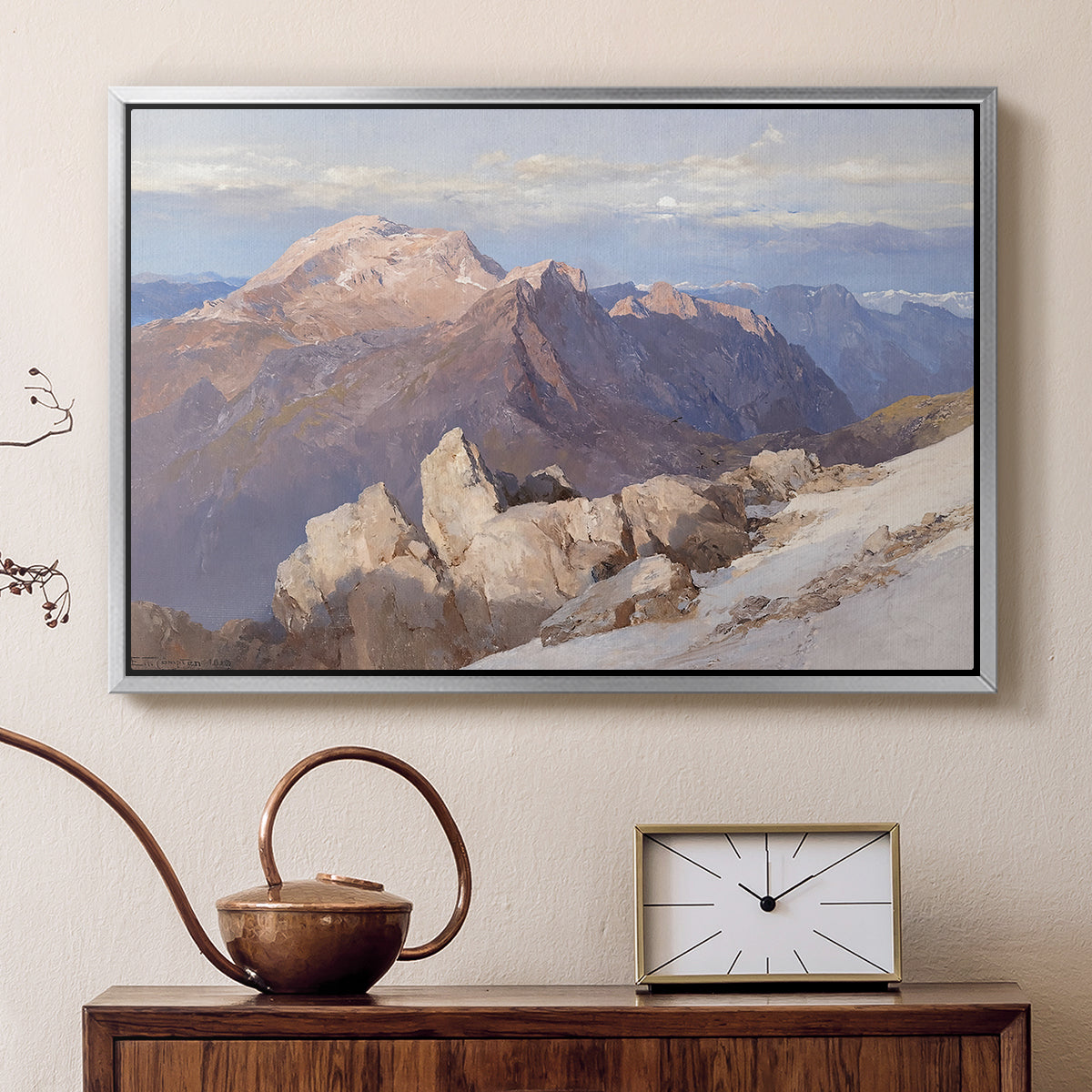 Silver floater framed canvas featuring a high vantage point overlooking rugged mountain terrain, displayed above a cabinet in a soft-toned living room.