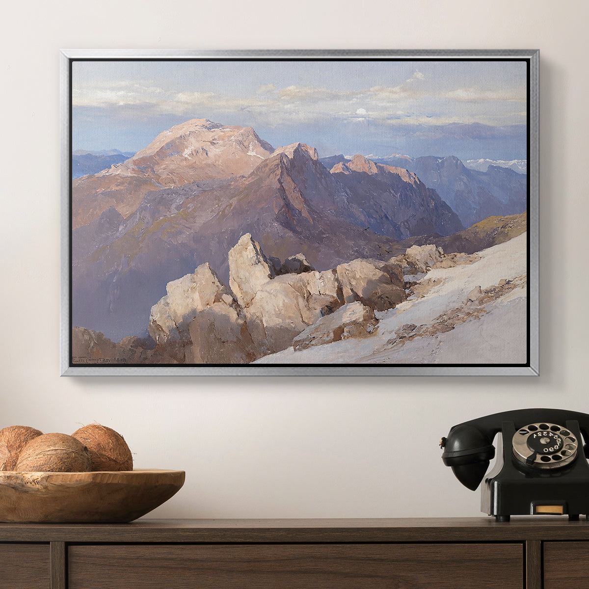 Hoher Göll from Watzmann-Hocheck, 1919 by Edward Theodore Compton in a silver floater framed canvas displayed above a console table in a hallway, featuring an expansive mountainous landscape with natural depth.